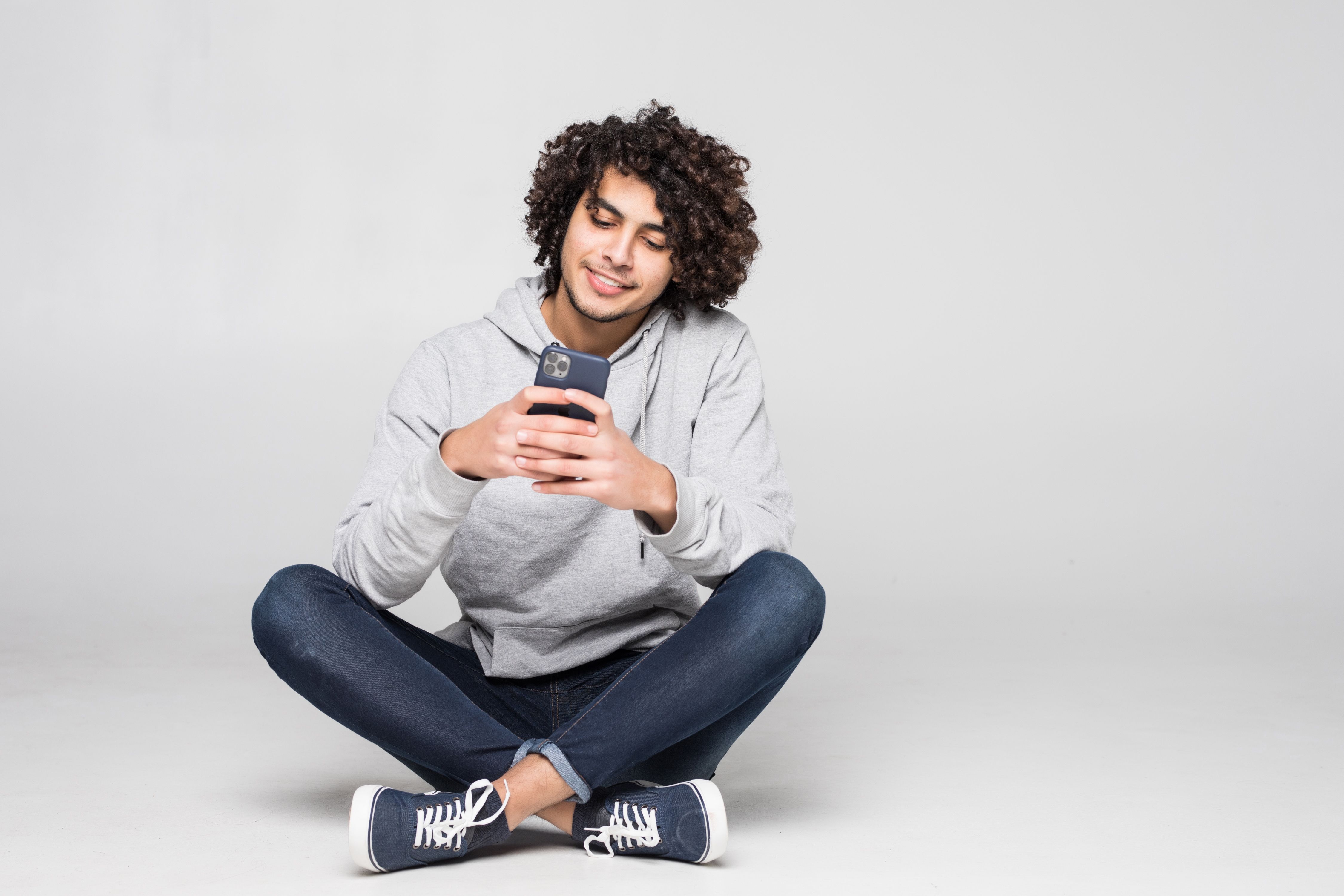 https://fbonline-blog-production.s3.sa-east-1.amazonaws.com/young_curly_man_sitting_floor_sending_message_isolated_white_wall_99134da400.jpg